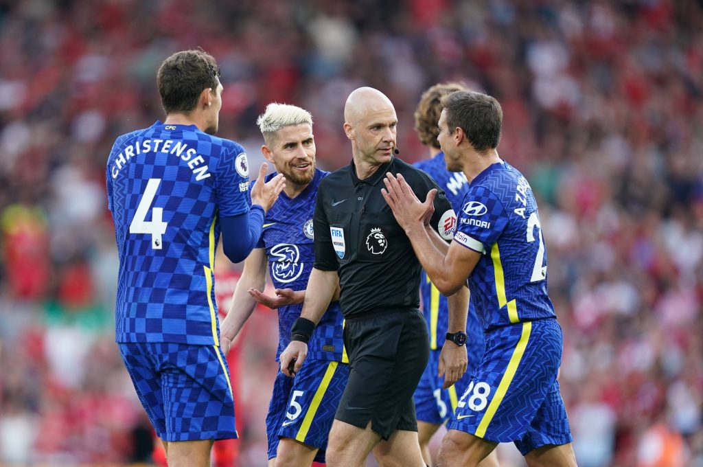 Chelsea players arguing with Anthony Taylor. 