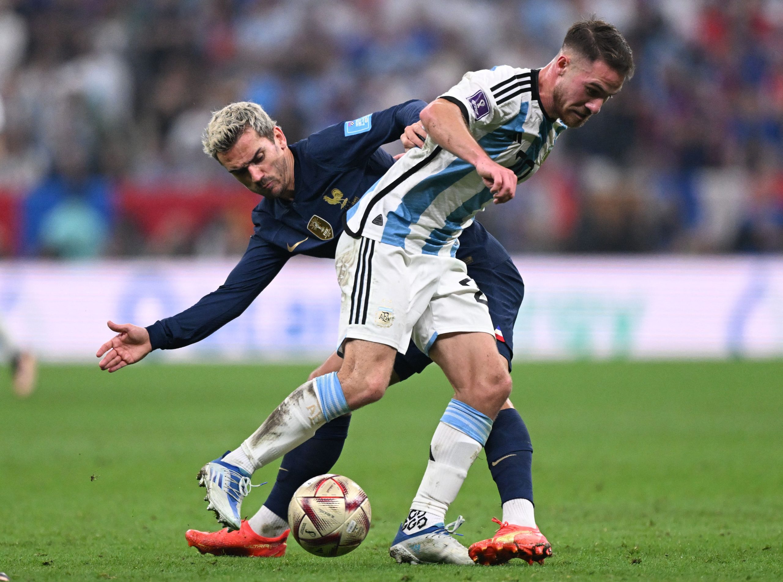 Antoine Griezmann of France with Alexis Mac Allister of Argentina at the 2022 FIFA World Cup final.