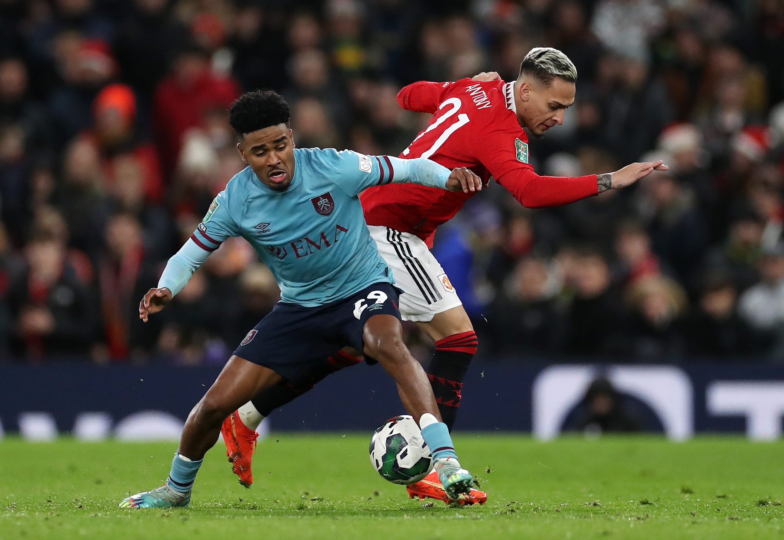 Ian Maatsen of Burnley is challenged by Antony of Manchester United during a Carabao Cup Fourth Round match.