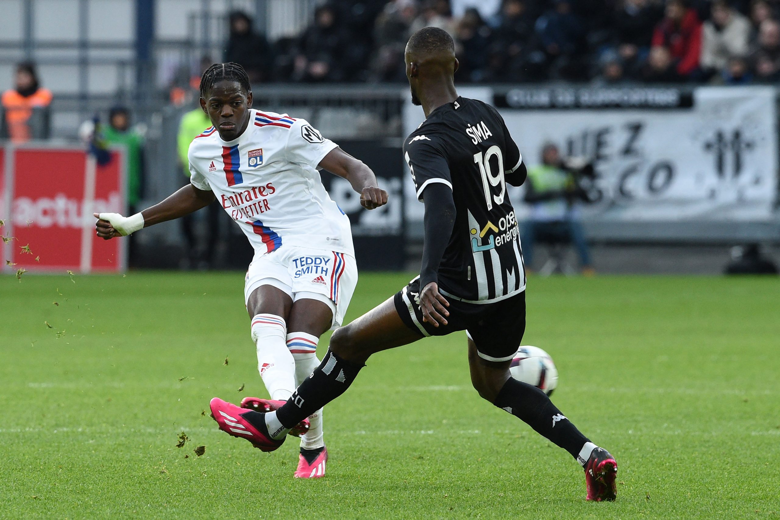 Lyon's French defender Castello Lukeba (L) fights for the ball with Angers' Senegalese forward Abdallah Sima (R).