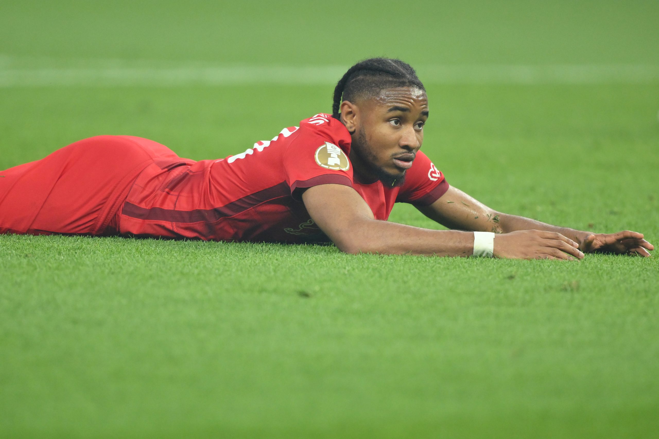 Christopher Nkunku of RB Leipzig lies on the pitch during the DFB Cup final match against Eintracht Frankfurt at Olympiastadion.
